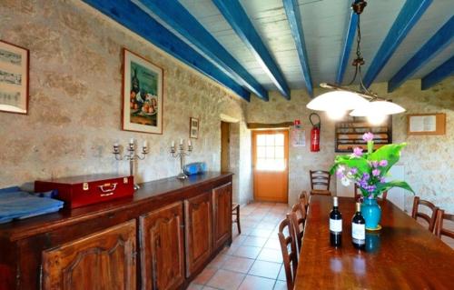 DondasGîte La Maison du Bonheur的用餐室配有带瓶装葡萄酒的桌子