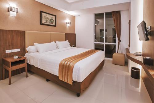 三宝垄The Azana Hotel Airport Semarang的酒店客房设有一张大床和一台电视。