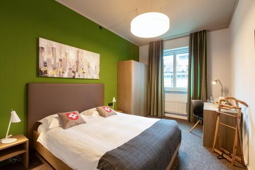 伯尔尼班德广场巴朗酒店的一间卧室设有一张床和绿色的墙壁