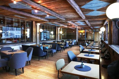 萨尔巴赫JUFA Alpenhotel Saalbach的餐厅设有木制天花板和桌椅