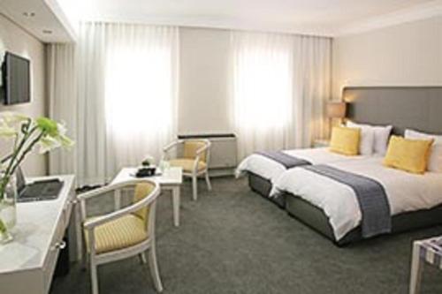 开普敦Hollow on the Square City Hotel的配有一张床和一张书桌的酒店客房