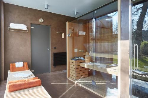 HuldenbergB&B Park7 Wavre - Leuven的一间带玻璃淋浴和长凳的浴室