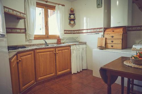 莱图尔Casa rural rincón de Letur的厨房配有木制橱柜、水槽和窗户。