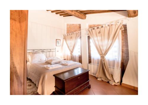 泰里乔拉Casale Podernovo的一间卧室配有一张床、一张桌子和窗帘