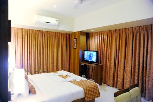拉特纳吉里Hotel Sea Fans的酒店客房,配有床和电视