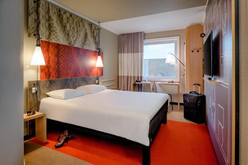 明斯特Ibis Münster City的酒店客房设有一张白色大床和一个窗户。