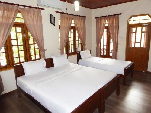 拜蒂克洛里维埃拉度假酒店的带窗户的客房内的两张床