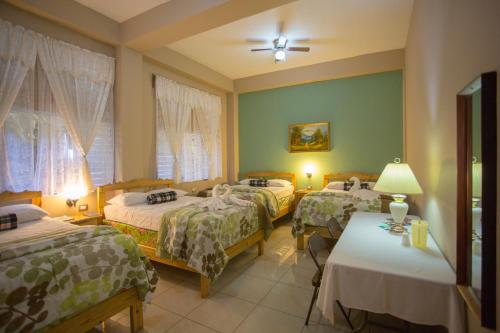 科潘省圣罗莎Hotel San Jorge的酒店客房设有三张床和一张桌子