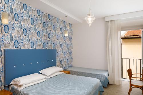 索伦托德尔科索酒店的一间卧室设有两张床和蓝色的墙壁