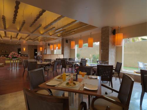 迈索尔阔鲁姆酒店的餐厅内带桌椅的用餐室
