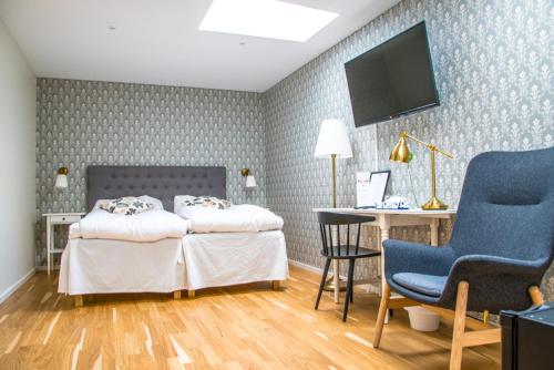 林德斯贝里林德斯贝里城镇酒店的一间卧室配有两张床、一张桌子和一台电视。