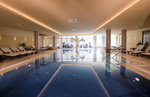 奥斯赛拜-屈隆斯博恩屈隆斯伯恩维尔四季酒店的一座配有桌椅的酒店游泳池