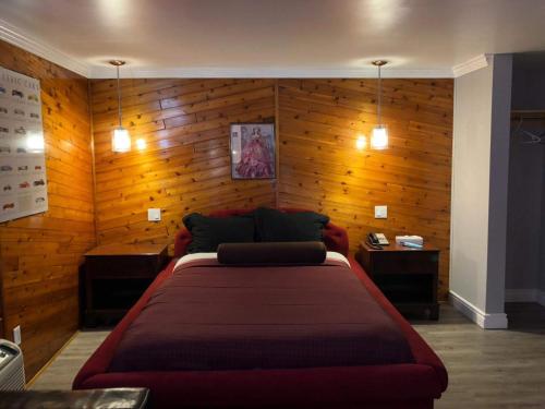 伦敦庭院汽车旅馆的一间卧室设有一张大床和木墙