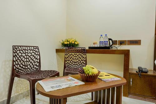 纳盖科伊尔Hotel Ramraj Regency的配有桌子、两把椅子和柜台的房间