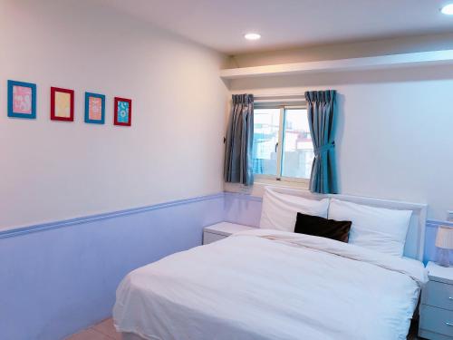 大溪孔雀大旅社的卧室配有白色的床和窗户。