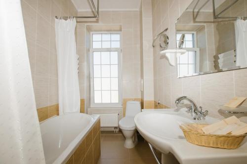 梁赞康裕施尼德沃尔旅馆的带浴缸、卫生间和盥洗盆的浴室