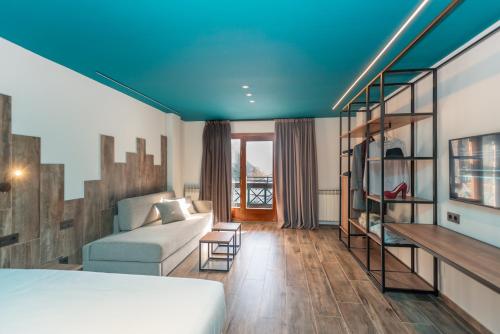 阿林萨尔Ushuaia, The Mountain Hotel的一间设有床、沙发和楼梯的房间