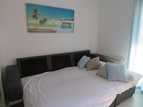 阿尔卡尼斯Alcañiz Flats I的卧室内的一张带白色床单和枕头的床