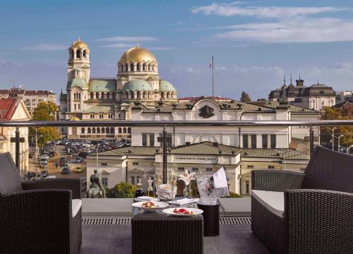 索非亚索非亚洲际酒店的带有食物盘的桌子,在带有建筑物的阳台上
