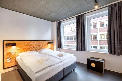 明斯特H.ostel Münster的酒店客房设有一张床和两个窗户。