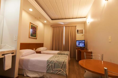 圣若泽杜斯坎普斯迪朱利奥酒店的酒店客房设有两张床和电视。