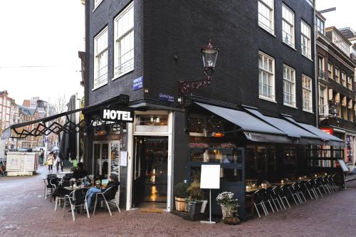 阿姆斯特丹角落之家酒店的咖啡馆,人们坐在大楼外的桌子旁