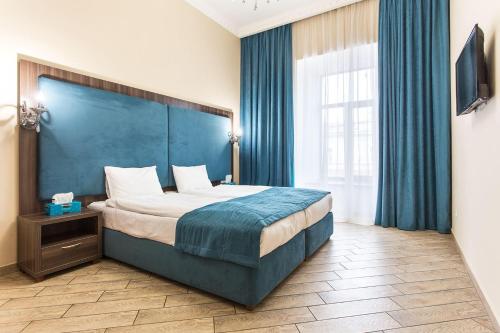 敖德萨Hotel Baron的一间卧室配有一张大床和蓝色床头板