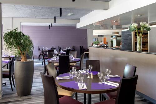 尚贝里Best Western Alexander Park Chambéry的一间带桌椅的餐厅和一间酒吧