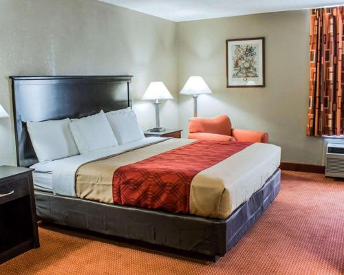 伯灵顿Econo Lodge Burlington I-40的配有一张床和一把椅子的酒店客房