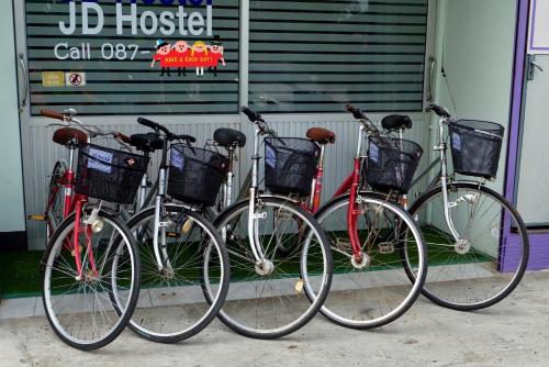 大城JD hostel的三辆自行车停在建筑物前,彼此相邻