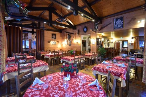 莫尔济讷索利酒店的餐厅配有桌椅和红色桌布