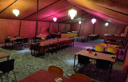 斯潘格米克P3 Camp Pangong的大房间设有桌椅和钢琴