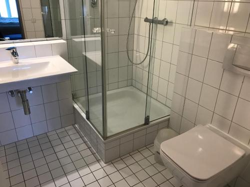 青斯特Komfortapartment Zingster-Meerblick的带淋浴、卫生间和盥洗盆的浴室