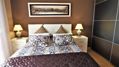 蒙特加特Helena Seaview & Beach-apartment的一间卧室配有一张带枕头的床和两盏灯。