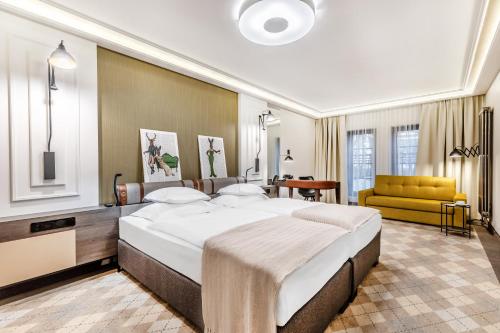 比亚韦斯托克Hotel Traugutta3的一间大卧室,配有一张大床和一张黄色的沙发