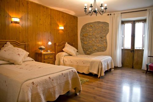 San MartínCasa Rural Lazkano en Sierra de Urbasa的酒店客房设有两张床和吊灯。