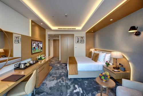 迪拜The S Hotel Al Barsha的配有一张床和一张书桌的酒店客房