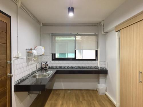 甲米镇您好公寓的白色的厨房设有水槽和窗户