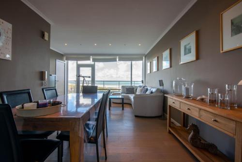 布列登Panoramic & Modern apartment with sea view的客厅配有桌子和沙发