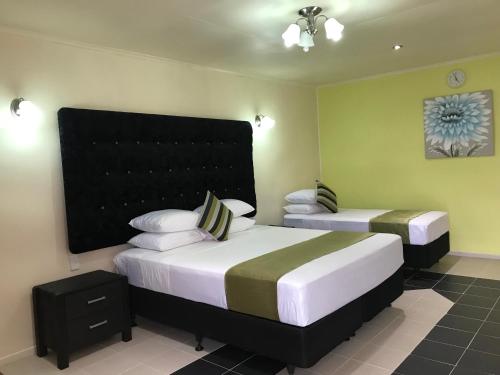 阿皮亚Moatoga Hotel的一间卧室配有两张床和床头板