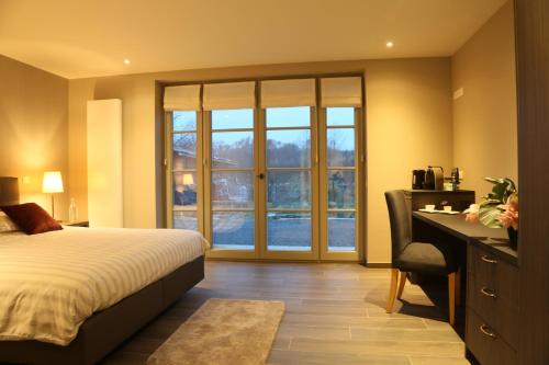 梅瑟Hof ter Dreef的一间卧室配有一张床、一张书桌和一个窗户。