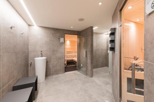 圣莫里茨蓝多林思家庭度假酒店的设有带步入式淋浴间和浴缸的浴室