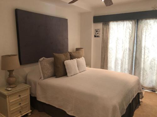 布里奇敦Brownes Condominium 1的卧室配有白色的床,墙上配有电视