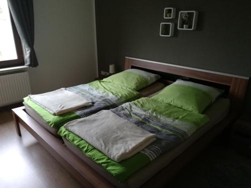 克拉嫩堡Ferienwohnung Wichtelgarten的一张带绿色床单和枕头的床