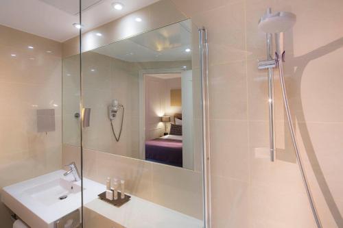 巴黎香榭丽舍大道伽利略酒店的带淋浴、盥洗盆和镜子的浴室