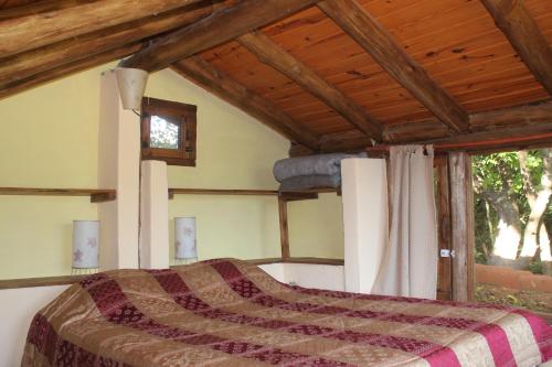 拉斯罗萨斯La Casa de Wanda的一间卧室设有一张床和木制天花板
