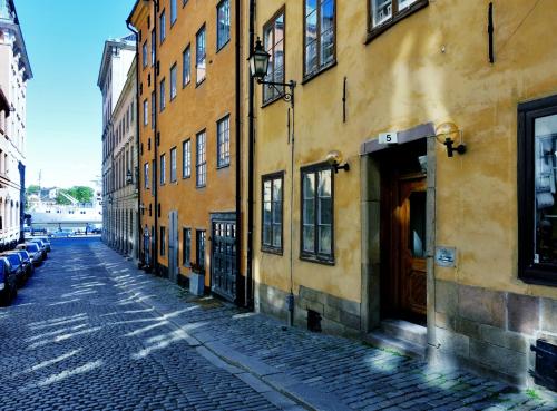 斯德哥尔摩Gamla Stan Apartments的城市中一条空荡荡的街道,有建筑