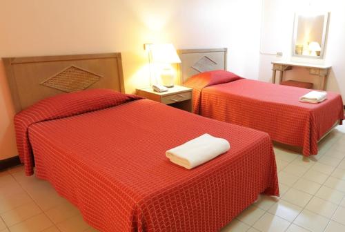 南邦宾大酒店的酒店客房,配有两张带红色床单的床