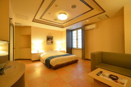 旭川蒂法尼成人酒店的一间大卧室,配有一张床和一张沙发