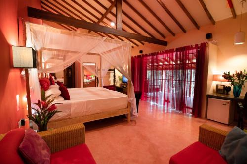 尼甘布迪克曼度假村“精品酒店”的一间卧室配有一张天蓬床和两把椅子